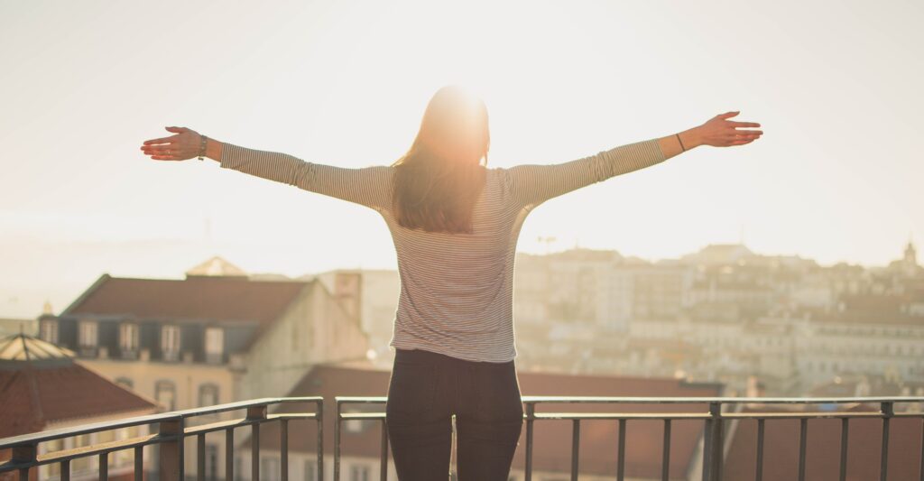 Woman standing on the balcony welcoming the morning sun